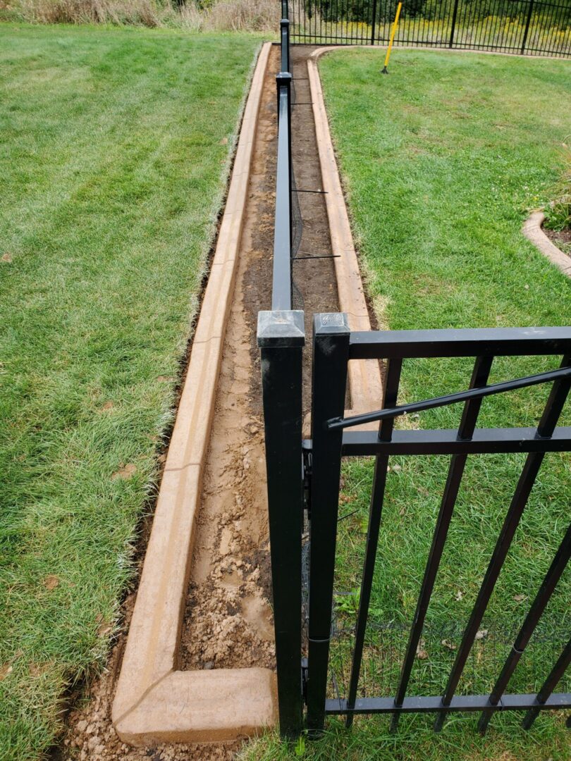 a black fence being set up around a yard